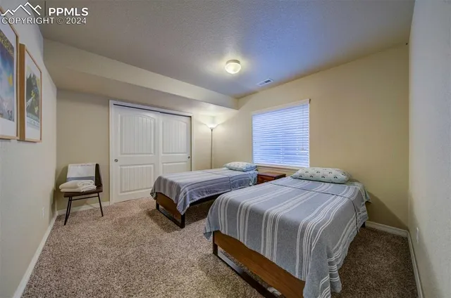 a bedroom with two beds and a chair