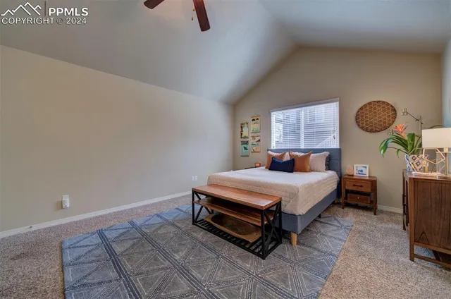 a bedroom with a bed a chandelier and a window