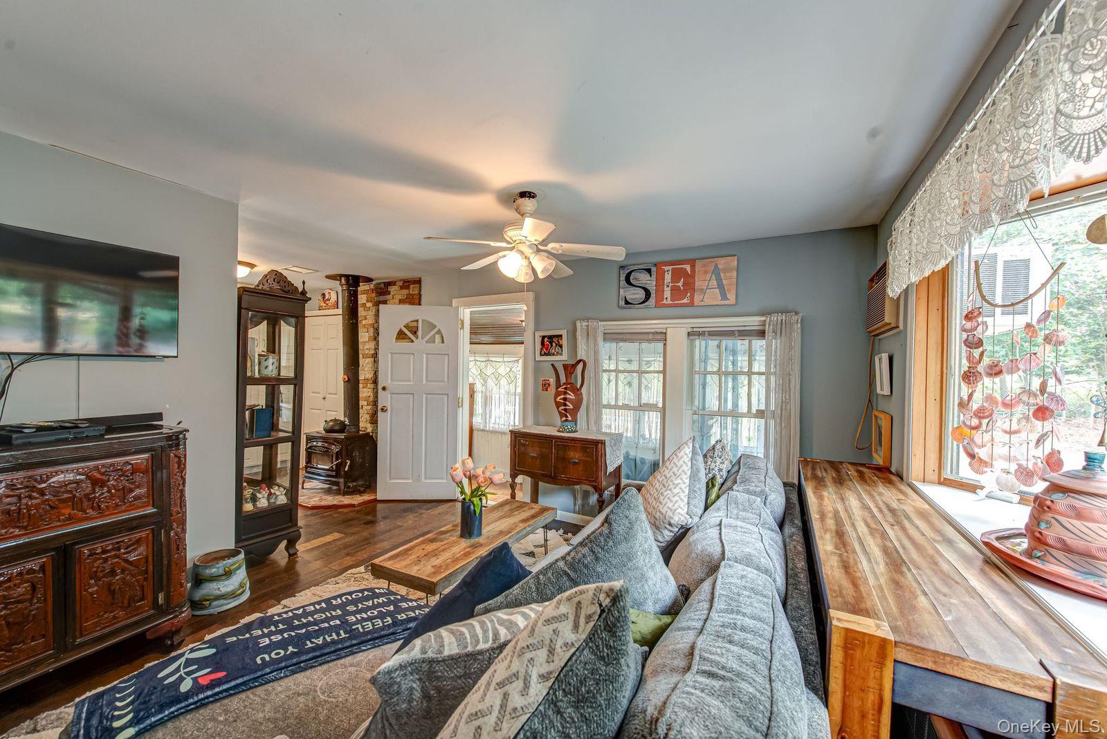 75 Upper Dock Road Kings Park, NY 11754 - Photo 4 of 30 a living room with furniture a flat screen tv and a fireplace