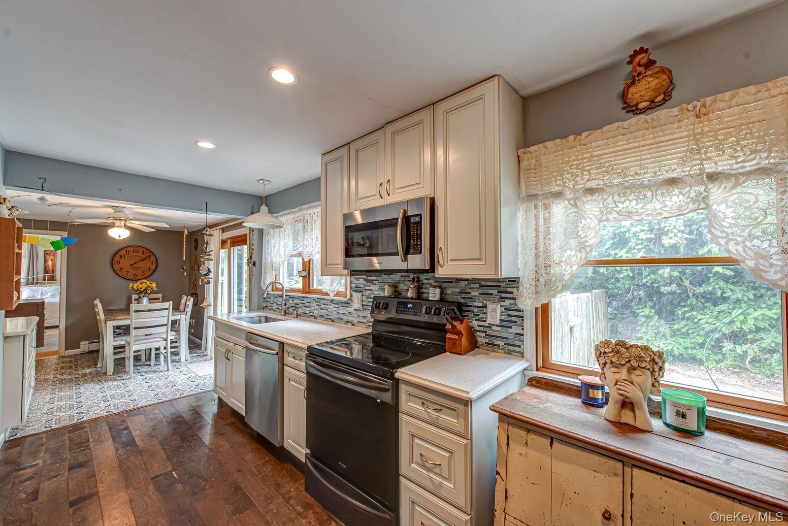 75 Upper Dock Road Kings Park, NY 11754 - Photo 9 of 30 a kitchen that has a sink a stove and a wooden floor