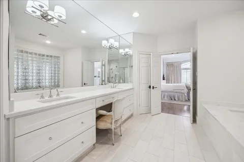 a spacious bathroom with a granite countertop sink a toilet mirror and bathtub