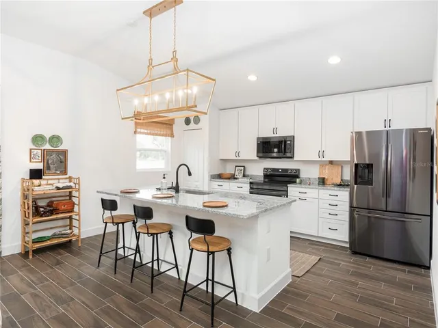 a kitchen with a sink stainless steel appliances and white cabinets