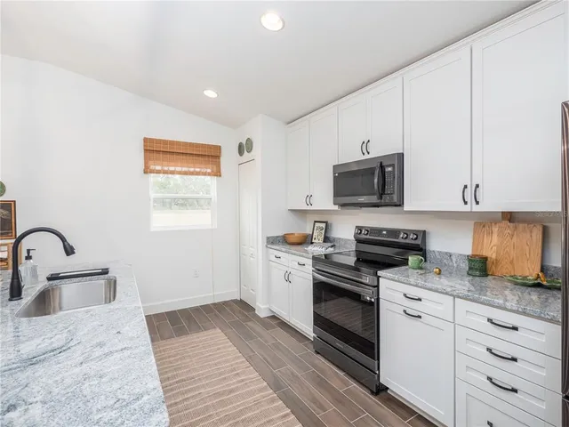 a kitchen with appliances a sink and cabinets