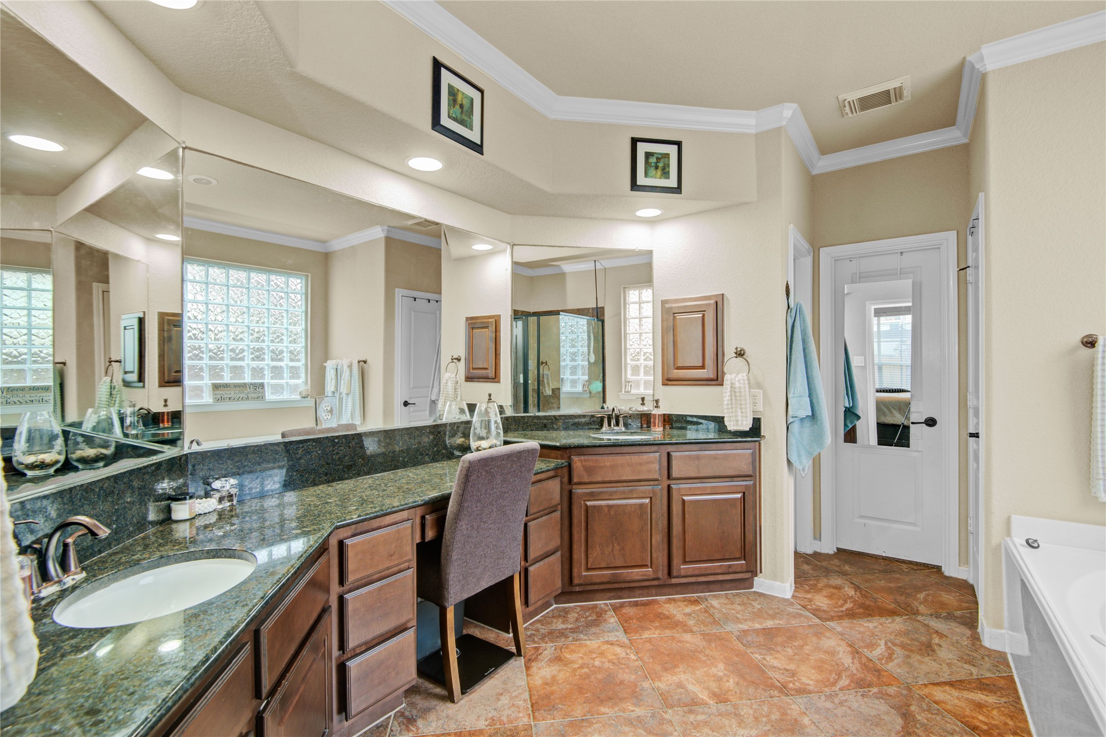 6007 Valhalla Drive Spring, TX 77379 - Photo 19 of 37 The spa-inspired primary ensuite features dual sinks, vanity seating, a soaking tub, and separate glass-enclosed shower.