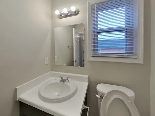 a bathroom with a sink a toilet and a mirror