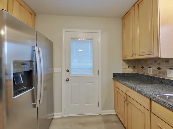 a kitchen with stainless steel appliances granite countertop a refrigerator and a stove