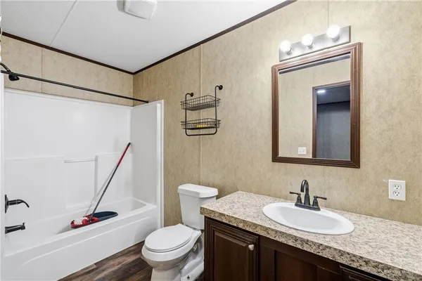 a bathroom with a granite countertop sink a mirror and a toilet