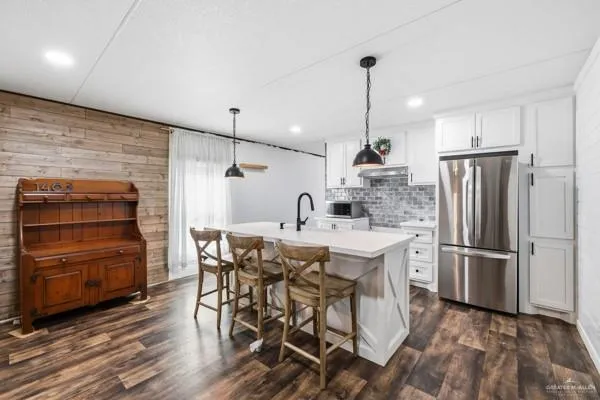 a kitchen with kitchen island a refrigerator stove and wooden floor