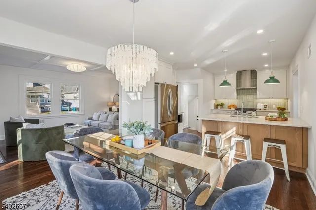 a view of a dining room with furniture a chandelier and wooden floor