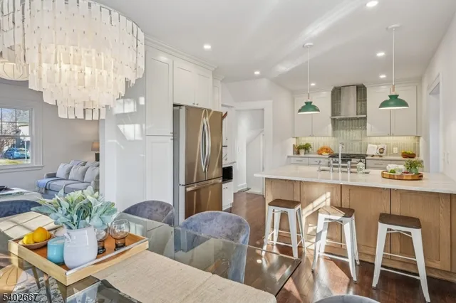 a kitchen with stainless steel appliances granite countertop a refrigerator and a dining table
