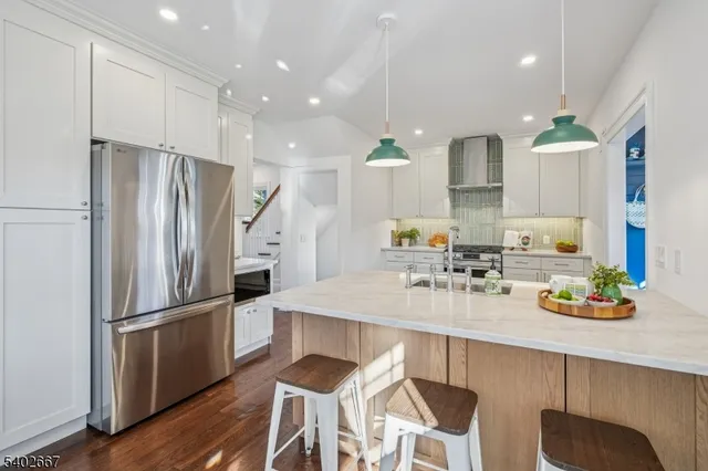a kitchen with refrigerator and chairs