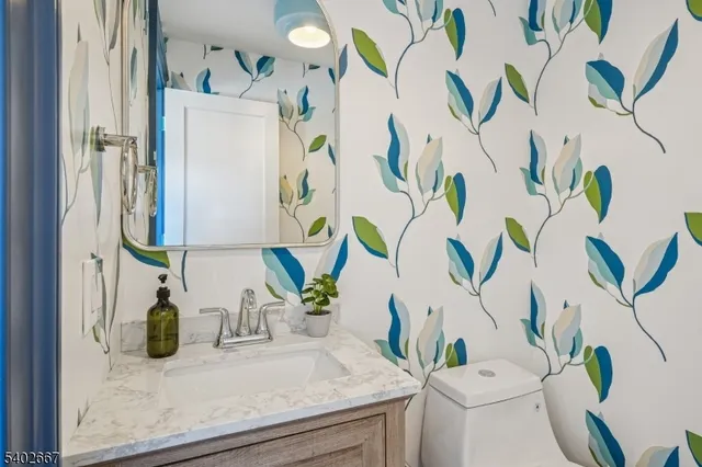 a bathroom with a sink a mirror and a potted plant