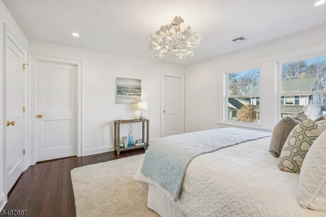 a bedroom with a large bed and a chandelier