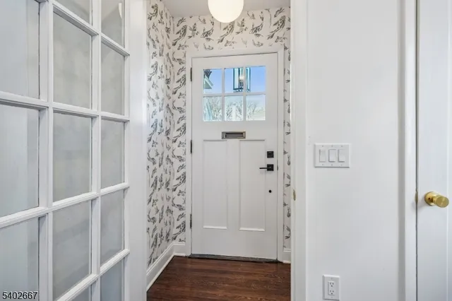 a view of a hallway with wooden floor and closet