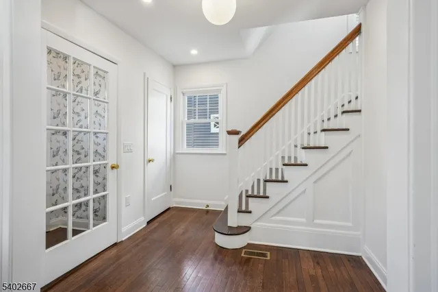 a view of entryway with wooden floor and stairs
