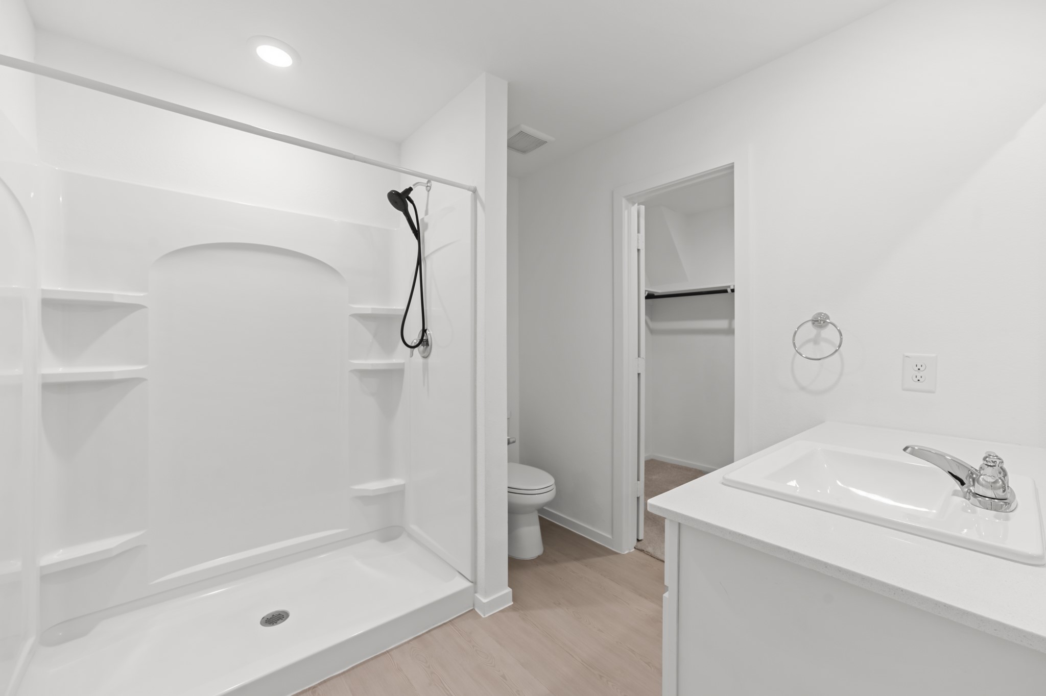 252 Houston Street Angleton, TX 77515 - Photo 27 of 49 Bright primary bath features a spacious walk-in shower with built-in shelving, a streamlined vanity, and direct access to the walk-in closet.