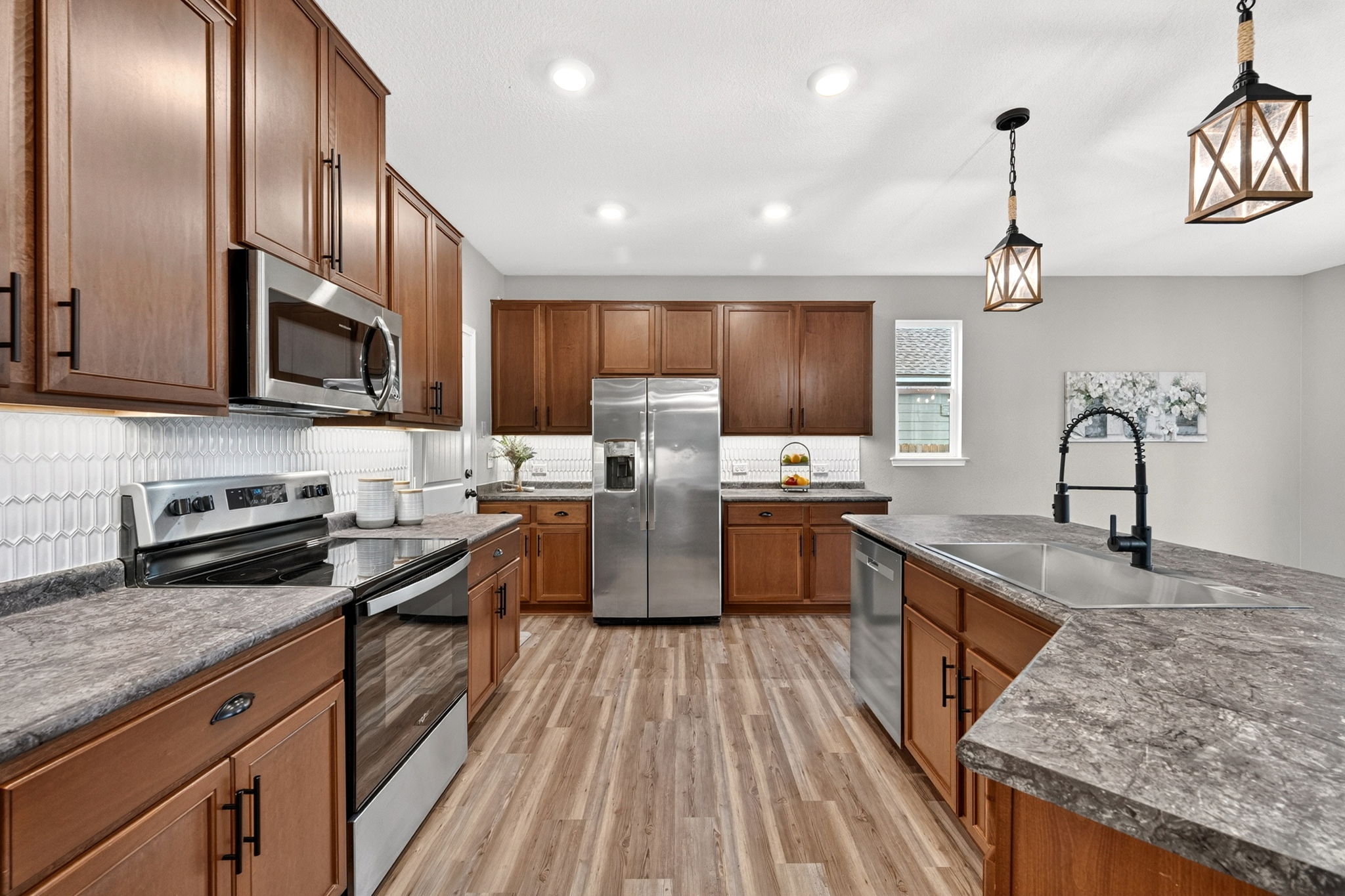 326 Linden Street Bastrop, TX 78602 - Photo 26 of 39 Large kitchen island with a deep single-bowl sink. Beautiful tile backsplash, undercabinet LED lighting & stainless steel appliances.