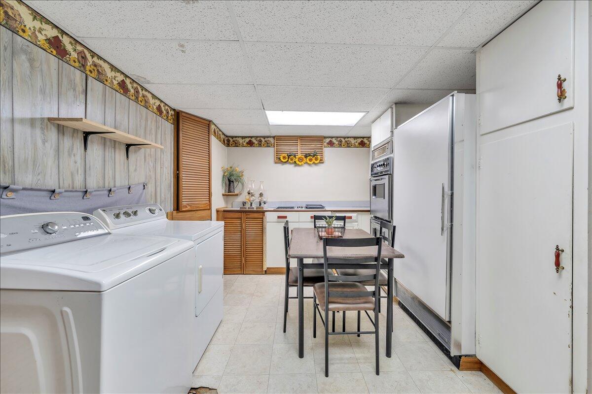 1525 West Ruritan Road Roanoke, VA 24012 - Photo 33 of 62 a kitchen with a sink a refrigerator and chairs