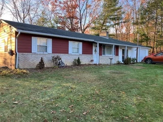 a view of a yard in front of a house with large tree