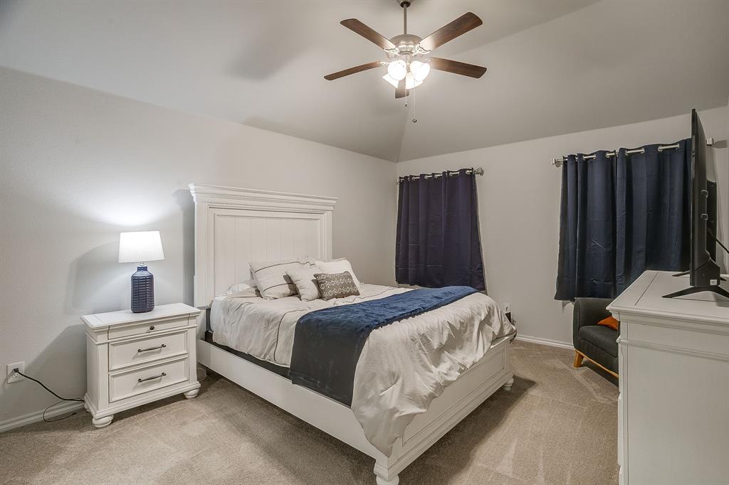 9912 Mescalbean Boulevard Crowley, TX 76036 - Photo 15 of 23 a bedroom with a bed and a chandelier