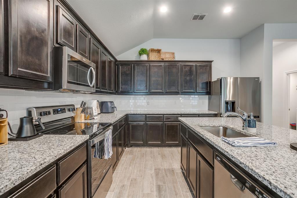 9912 Mescalbean Boulevard Crowley, TX 76036 - Photo 10 of 23 a kitchen with stainless steel appliances granite countertop a sink stove and refrigerator