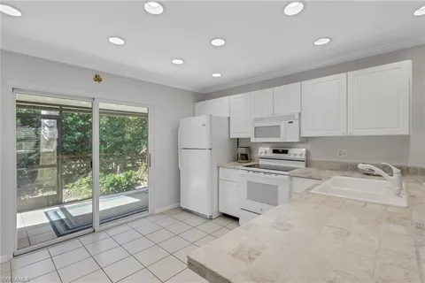 a kitchen with white cabinets and white appliances