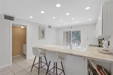 a kitchen with granite countertop a sink and chairs