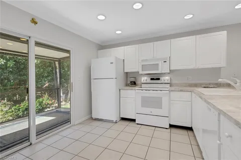 a kitchen with white cabinets and white appliances