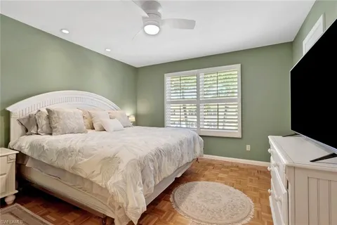 a spacious bedroom with a bed and a flat screen tv