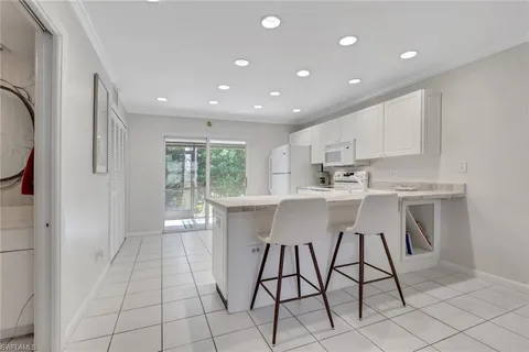 a kitchen with stainless steel appliances kitchen island granite countertop a sink and a refrigerator