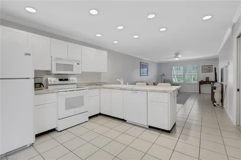 a kitchen with white cabinets and white appliances