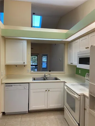 a kitchen with stainless steel appliances white cabinets and a refrigerator
