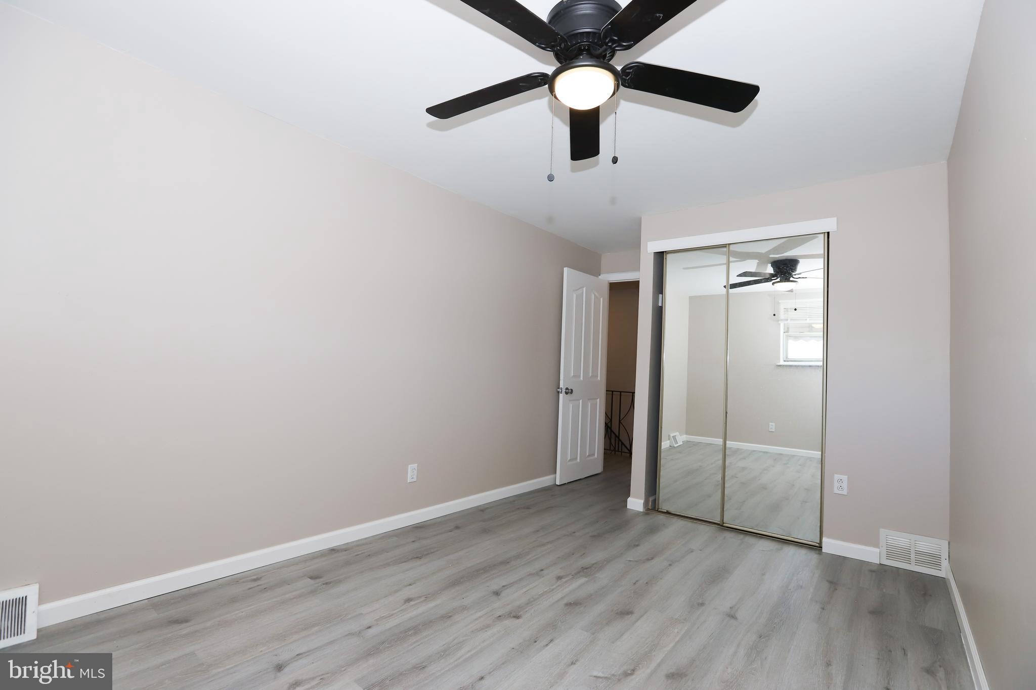 3559 Churchill Lane Philadelphia, PA 19114 - Photo 21 of 30 an empty room with wooden floor fan and windows