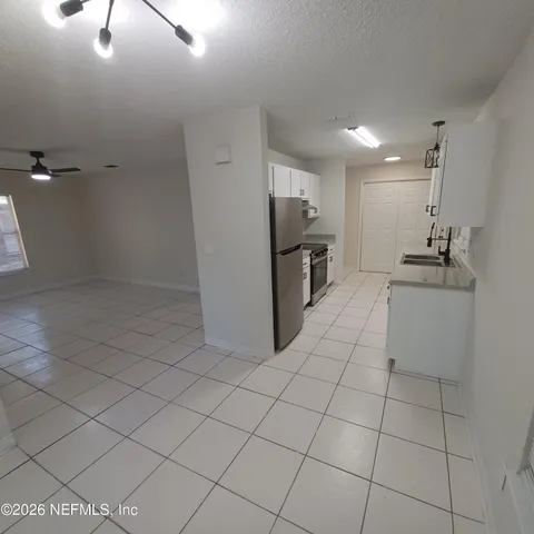 a kitchen with a sink a refrigerator and cabinets