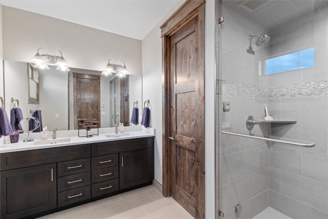 344 Angler Mountain Ranch Road Silverthorne, CO 80498 - Photo 17 of 32 a spacious bathroom with a double vanity sink a large mirror and shower