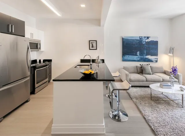 a living room with furniture and a refrigerator