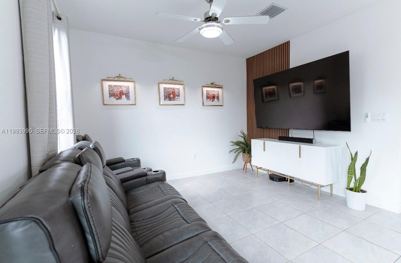 16222 Southwest 290th Terrace, Unit 16222 Homestead, FL 33033 - Photo 12 of 38 a living room with furniture and a flat screen tv