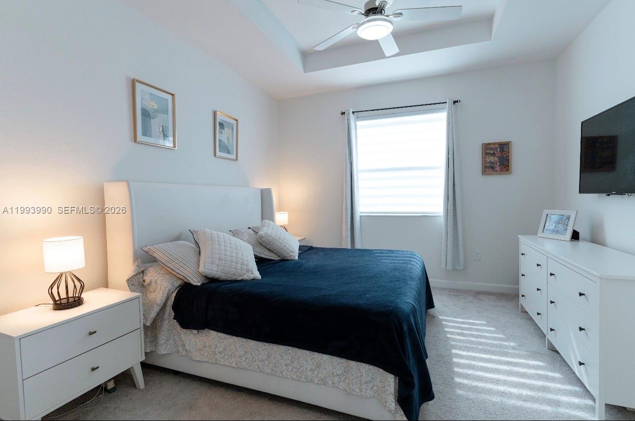 16222 Southwest 290th Terrace, Unit 16222 Homestead, FL 33033 - Photo 16 of 38 a bedroom with a bed and a flat screen tv