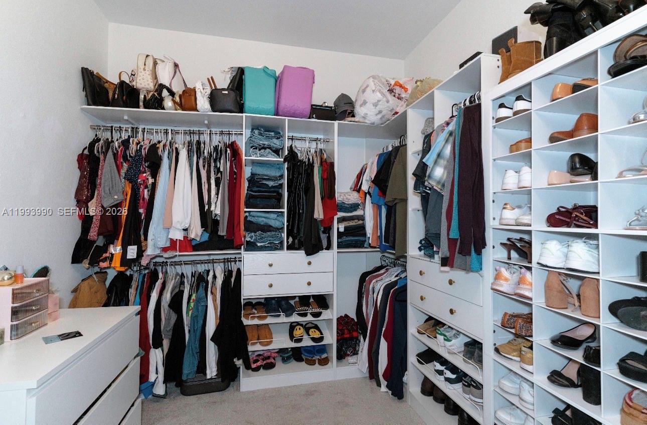 16222 Southwest 290th Terrace, Unit 16222 Homestead, FL 33033 - Photo 18 of 38 a view of walk in closet with clothes and shoes