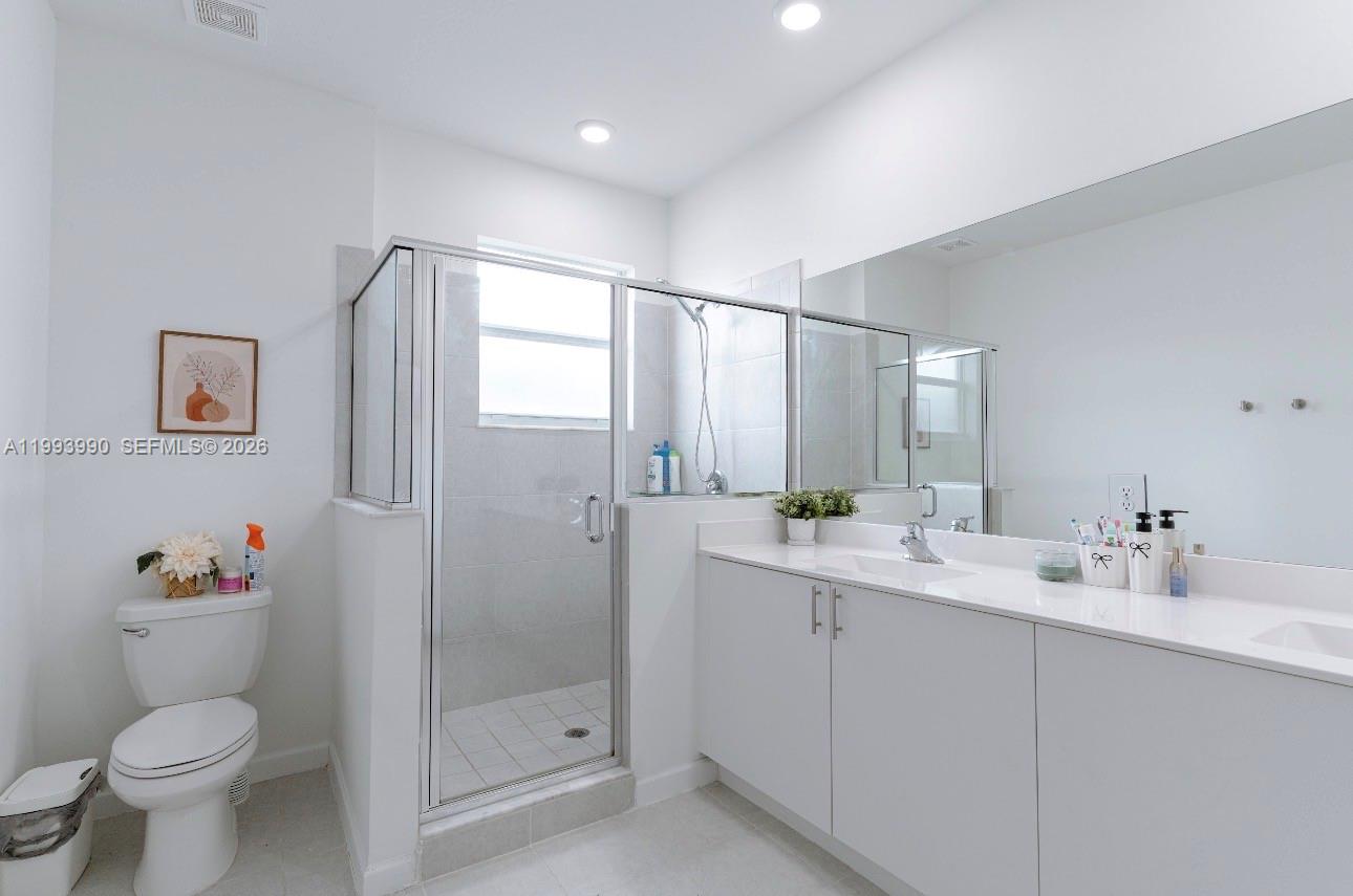16222 Southwest 290th Terrace, Unit 16222 Homestead, FL 33033 - Photo 19 of 38 a bathroom with a double vanity sink toilet and a mirror