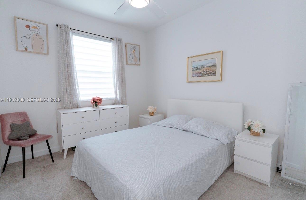 16222 Southwest 290th Terrace, Unit 16222 Homestead, FL 33033 - Photo 23 of 38 a bedroom with a bed and a window