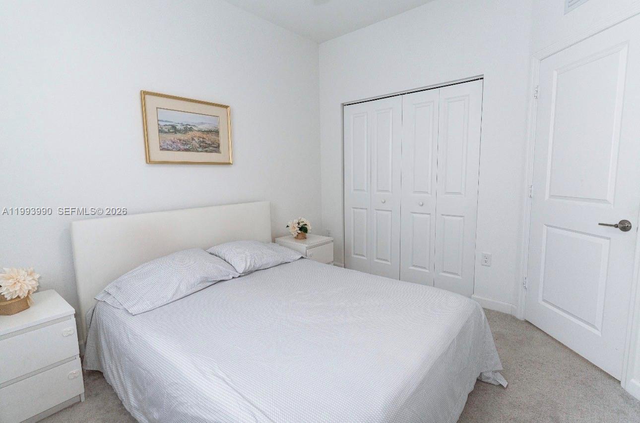 16222 Southwest 290th Terrace, Unit 16222 Homestead, FL 33033 - Photo 24 of 38 a bedroom with a bed and a walk in closet