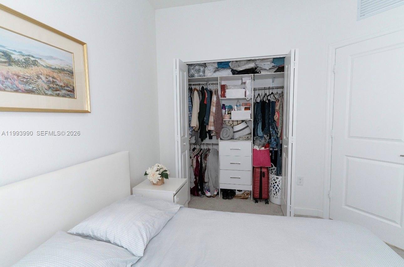 16222 Southwest 290th Terrace, Unit 16222 Homestead, FL 33033 - Photo 25 of 38 a bed room with a bed and a walk in closet