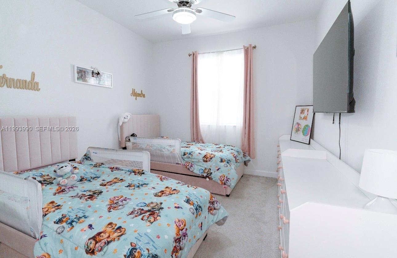 16222 Southwest 290th Terrace, Unit 16222 Homestead, FL 33033 - Photo 26 of 38 a bedroom with a bed and a flat screen tv
