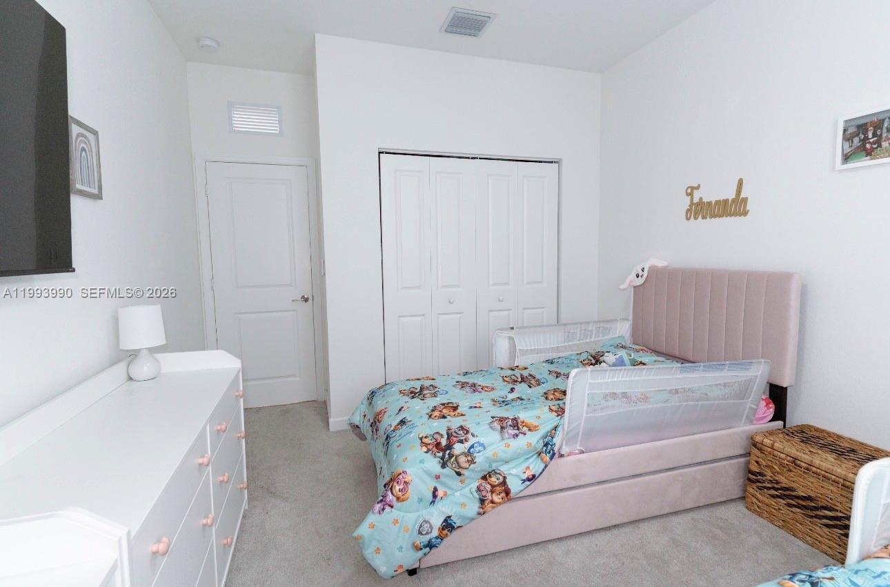 16222 Southwest 290th Terrace, Unit 16222 Homestead, FL 33033 - Photo 27 of 38 a bedroom with a bed and a couch