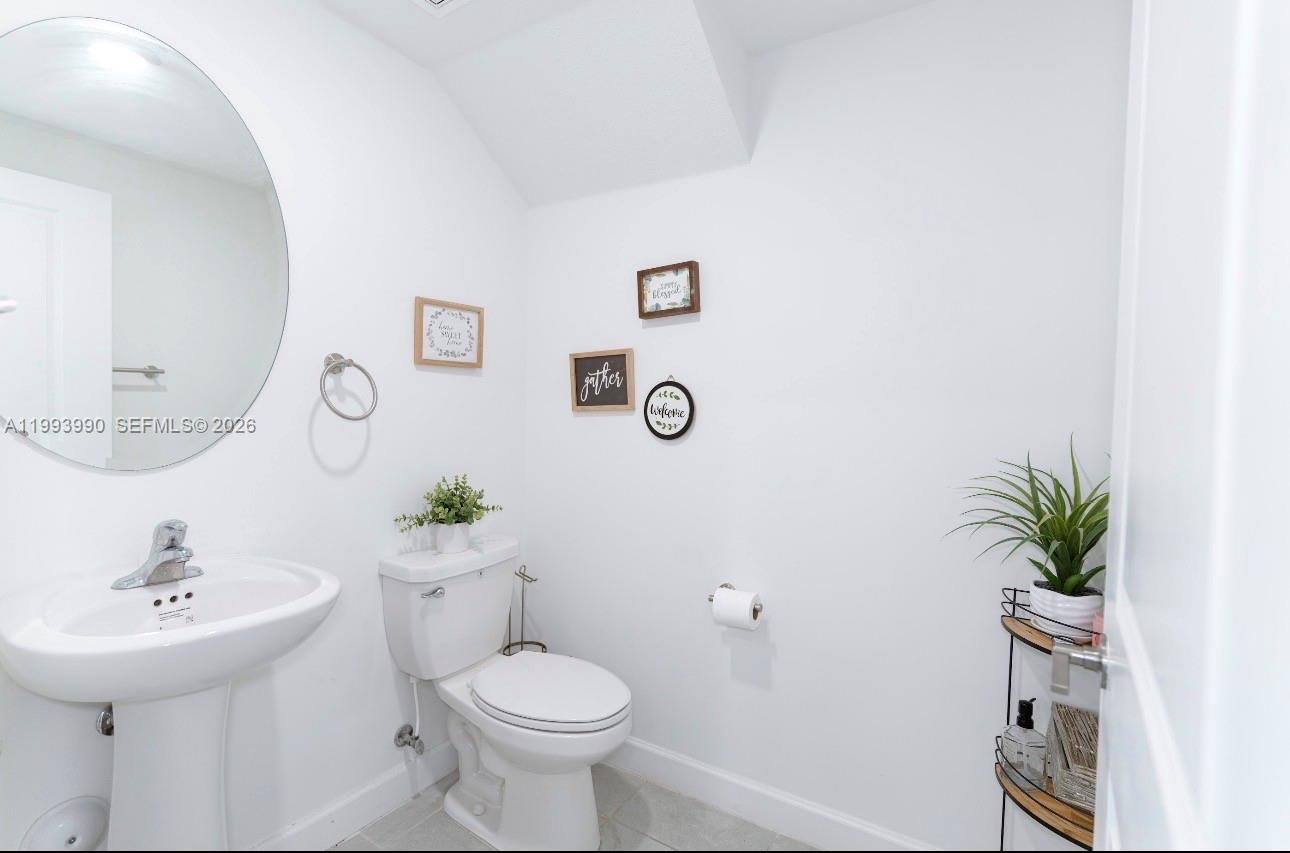 16222 Southwest 290th Terrace, Unit 16222 Homestead, FL 33033 - Photo 33 of 38 a bathroom with a sink toilet and a mirror
