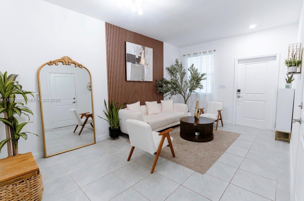 16222 Southwest 290th Terrace, Unit 16222 Homestead, FL 33033 - Photo 5 of 38 a living room with furniture and a potted plant