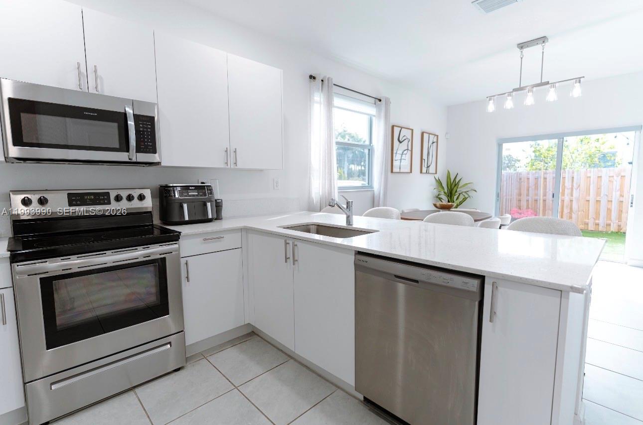 16222 Southwest 290th Terrace, Unit 16222 Homestead, FL 33033 - Photo 8 of 38 a kitchen with a sink stove and microwave