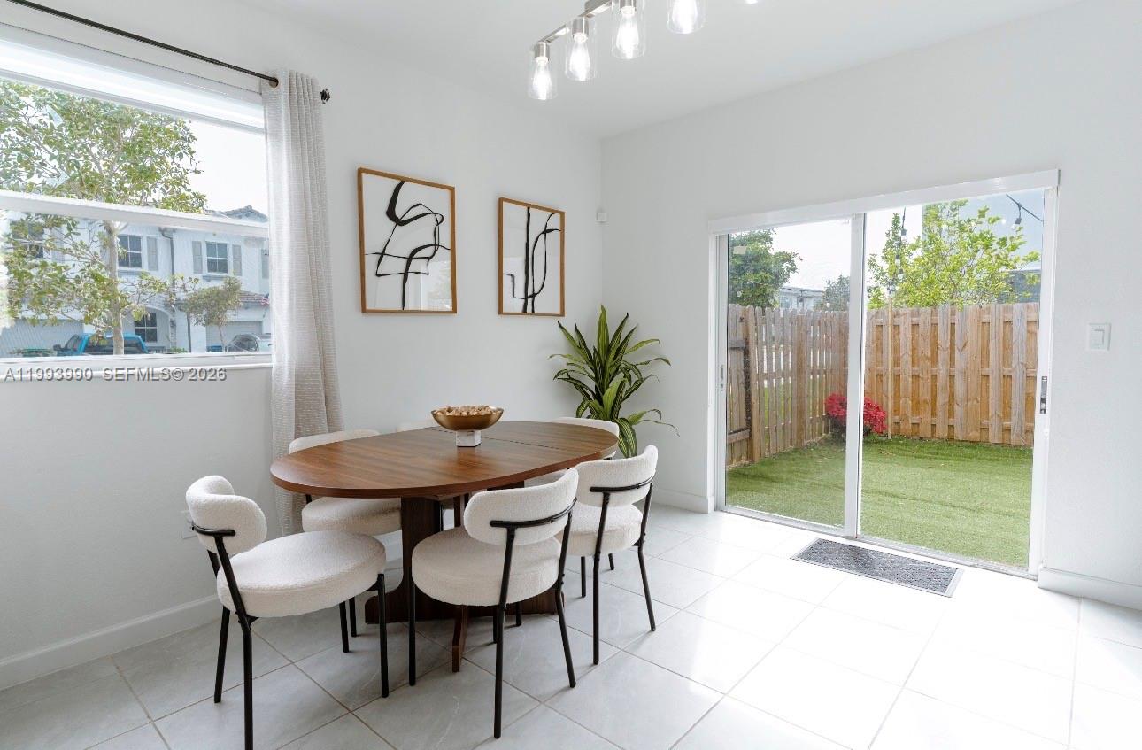 16222 Southwest 290th Terrace, Unit 16222 Homestead, FL 33033 - Photo 9 of 38 a view of a dining room with furniture and a yard