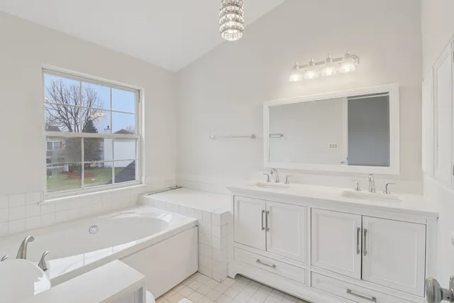 a bathroom with a tub sink and mirror